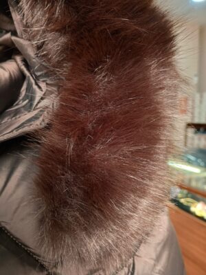Detalle del borde de pelo marrón de la capucha desmontable del anorak.